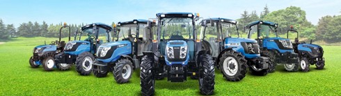 Blue Solis tractors lined up in a field under clear skies, showcasing compact utility models.