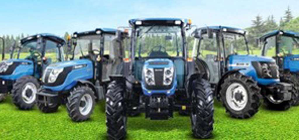 Blue Solis tractors lined up in a field under clear skies, showcasing compact utility models.