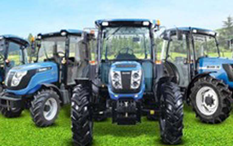 Blue Solis tractors lined up in a field under clear skies, showcasing compact utility models.