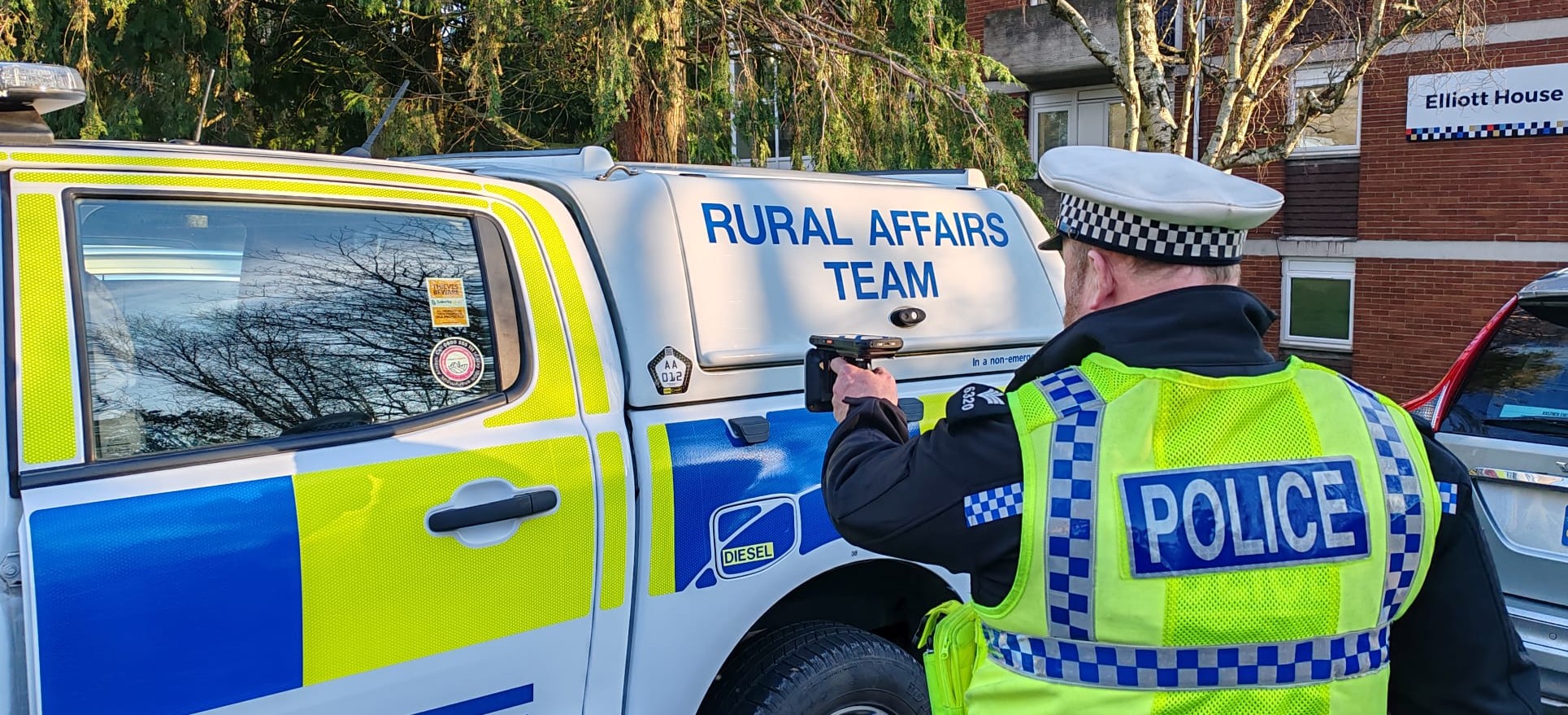Devon & Cornwall Police officer using a handheld scanner to check vehicle identification.