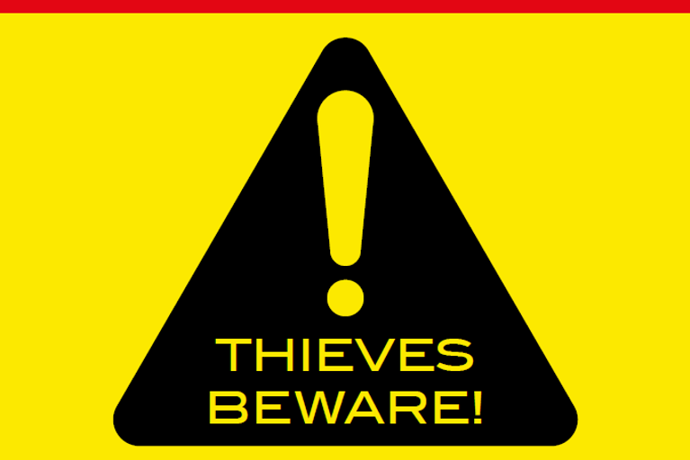 Bold VIN CHIP warning sign in red, black, and yellow, alerting thieves to security measures.