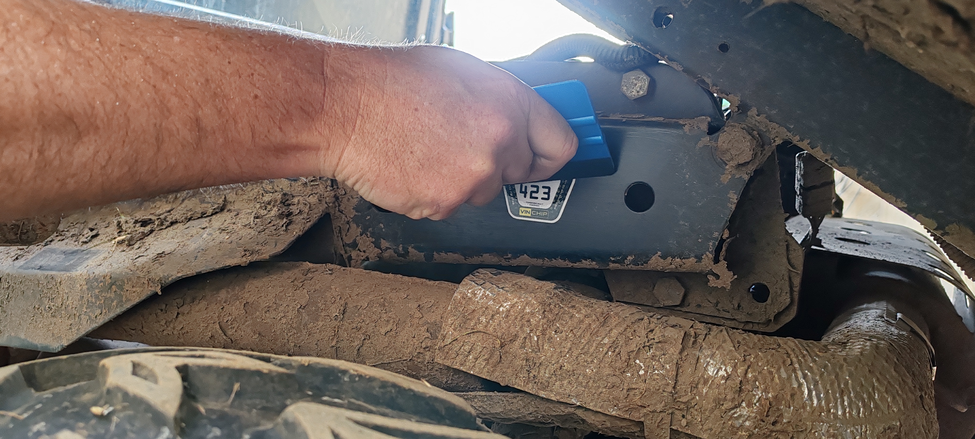 A VIN CHIP tamper-evident warning label being applied to a vehicle as part of security measures.