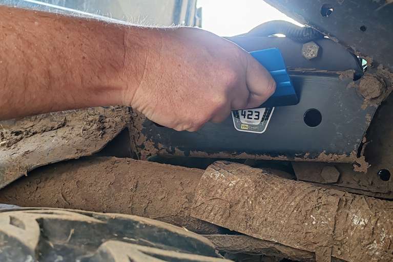 A VIN CHIP tamper-evident warning label being applied to a vehicle as part of security measures.