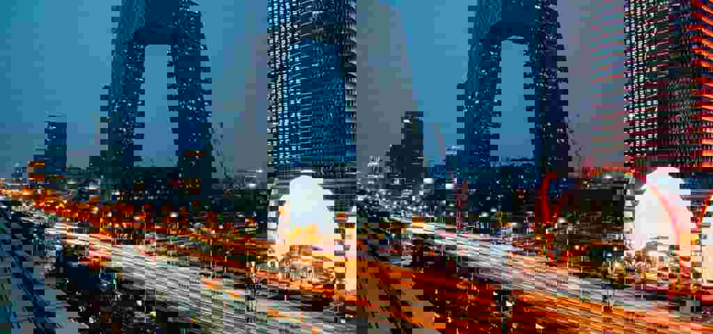 Modern cityscape at night, showcasing skyscrapers and vibrant lights.
