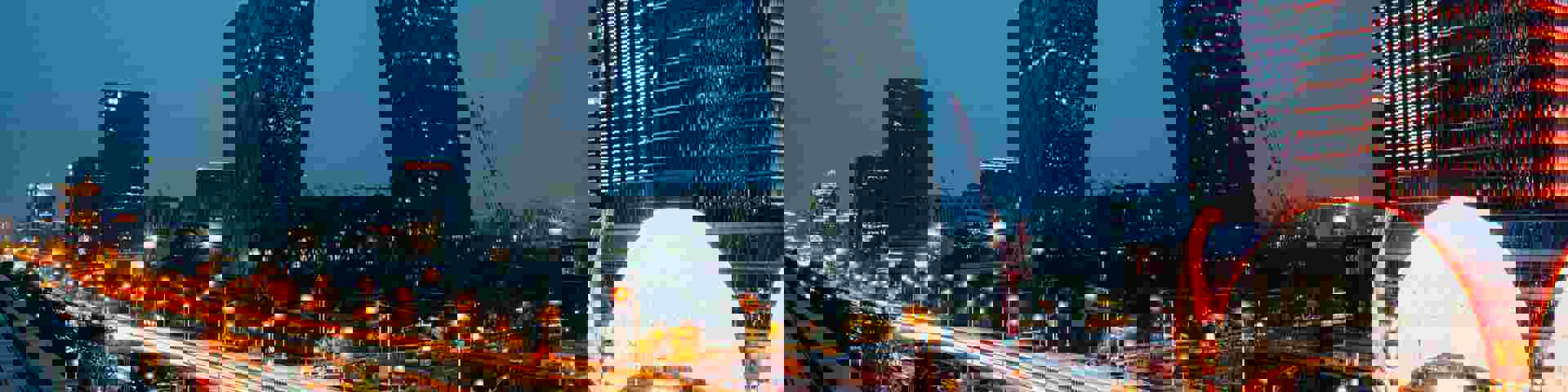 Modern cityscape at night, showcasing skyscrapers and vibrant lights.