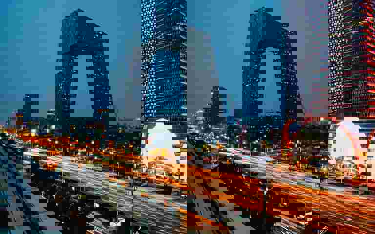 Modern cityscape at night, showcasing skyscrapers and vibrant lights.