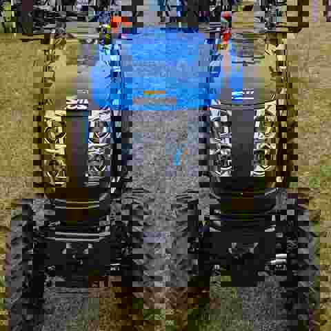 Blue Solis tractor with VIN Chip security marking on the front bonnet, displayed on a showground.