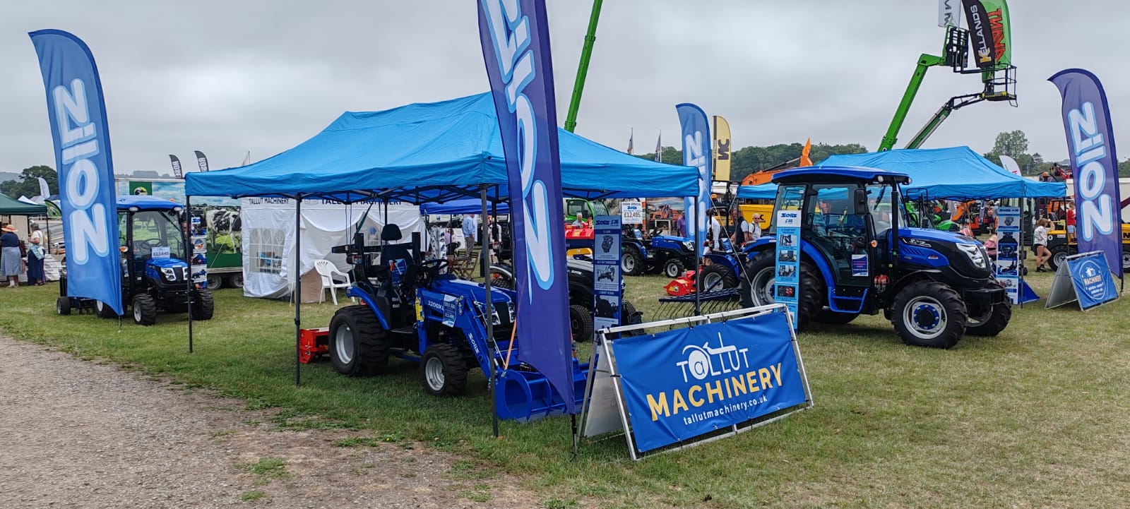 Tallut Machinery exhibition stand showcasing blue Solis tractors and equipment.