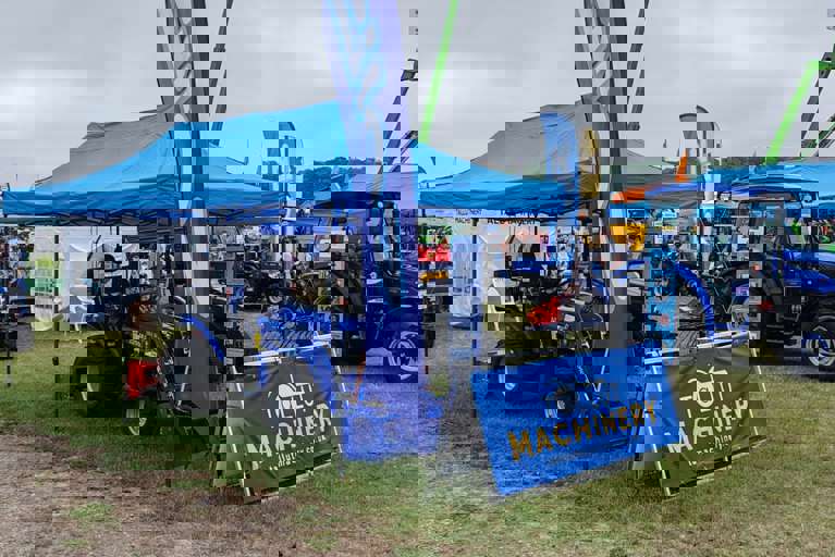 Tallut Machinery exhibition stand showcasing blue Solis tractors and equipment.