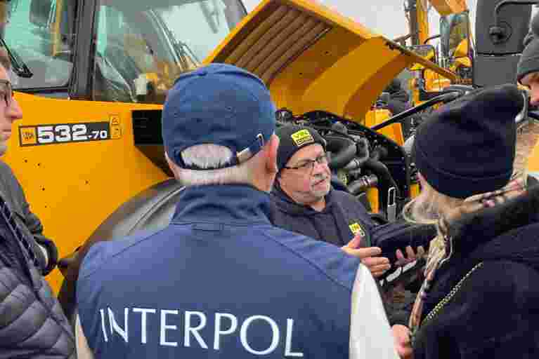 Trainer Nick Mayell providing practical training near yellow heavy plant machinery.