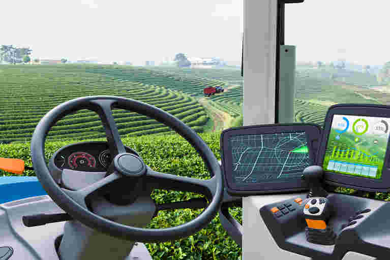 A GPS navigation screen in the cab of a tractor positioned in lush green fields.