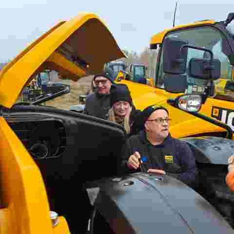 Nick Mayell instructing a group during hands-on training, all wearing winter coats and hats.