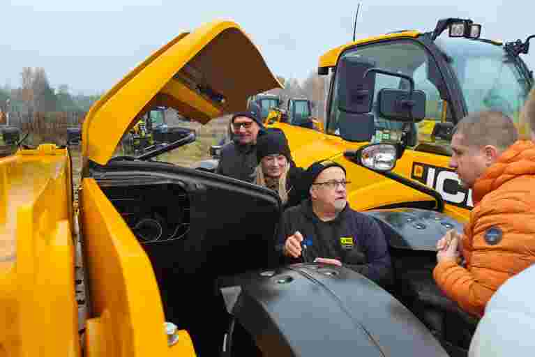 Nick Mayell instructing a group during hands-on training, all wearing winter coats and hats.