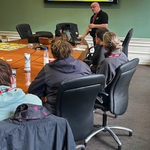 Police officers in a classroom setting attentively viewing a presentation on a large screen during a VIN CHIP training session.