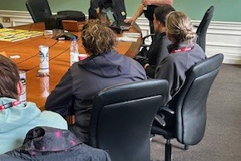 Police officers in a classroom setting attentively viewing a presentation on a large screen during a VIN CHIP training session.